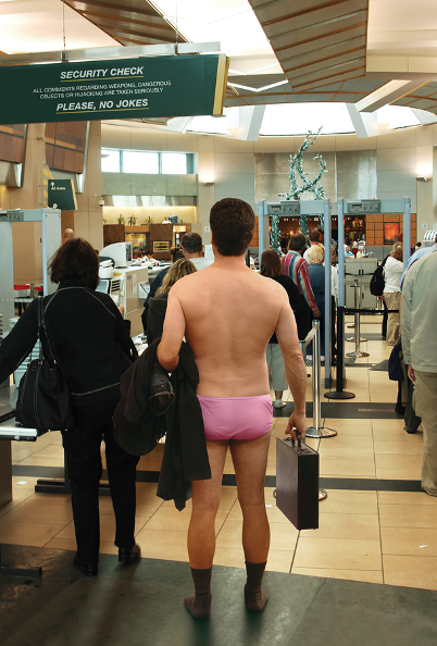 Man standing in his underwear waiting in line at airport security.
