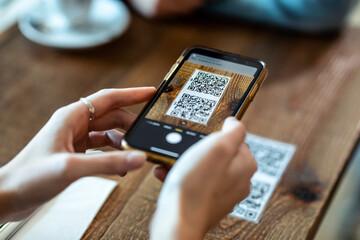Hands photographing a QR code
