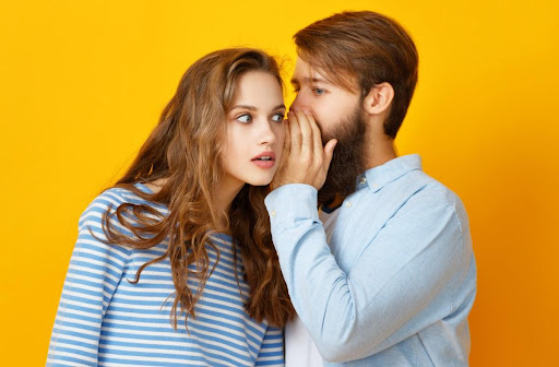 Man telling woman a secret