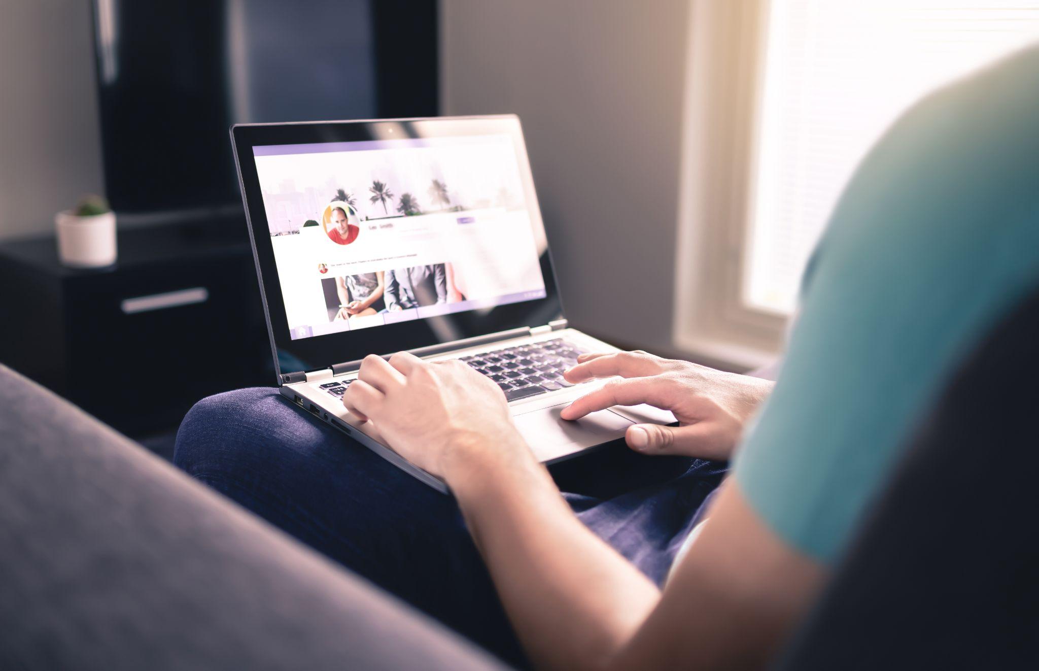 man sitting and browsing on a laptop