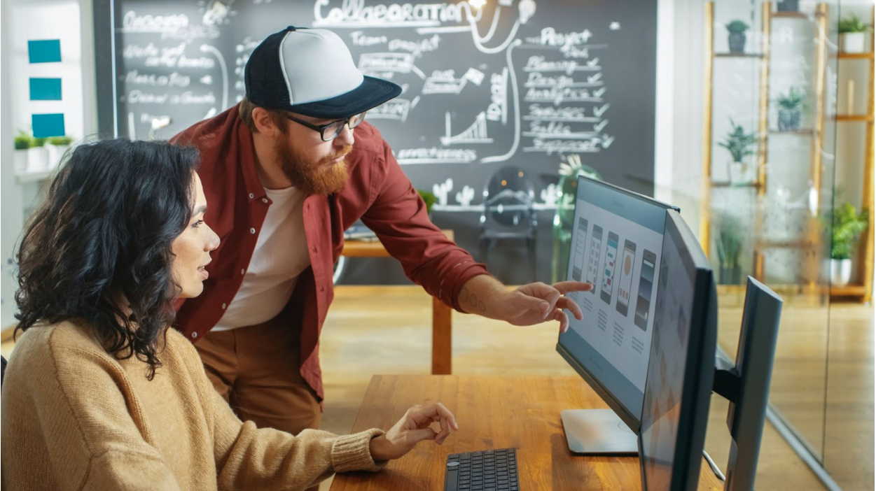 man and woman looking at computer monitor