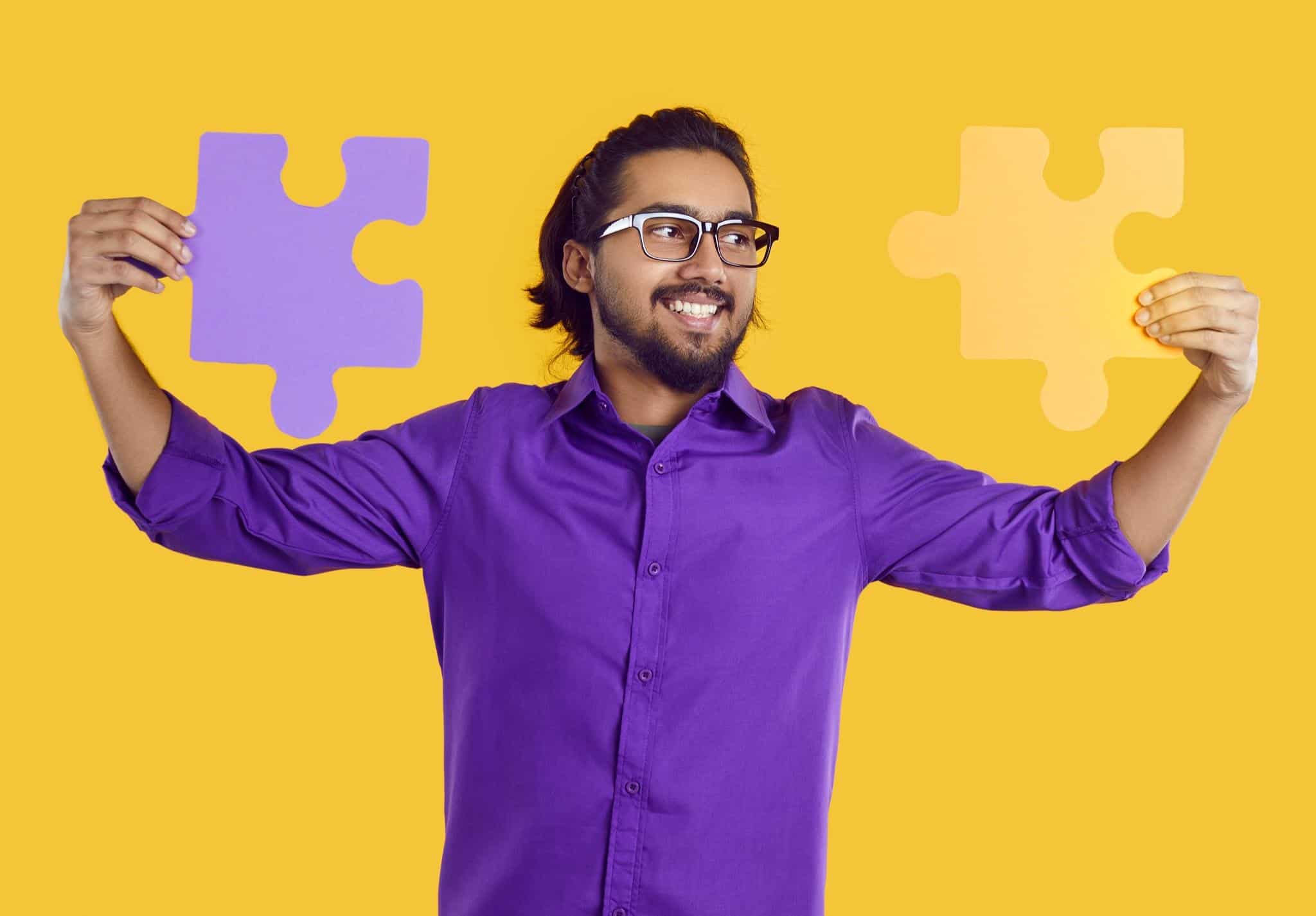 man holding two puzzles pieces