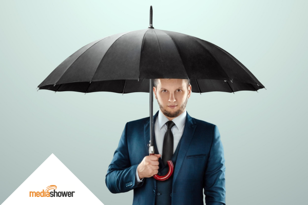 man in a suit holding an umbrella