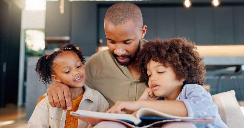 father reading a book to his two small children