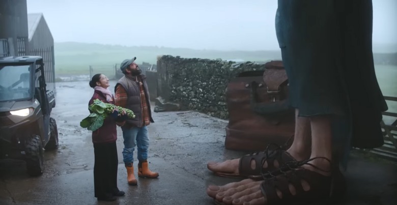 a couple in a small town looking up at a giant