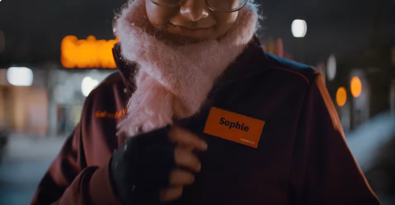 a sainsbury worker putting on her name tag