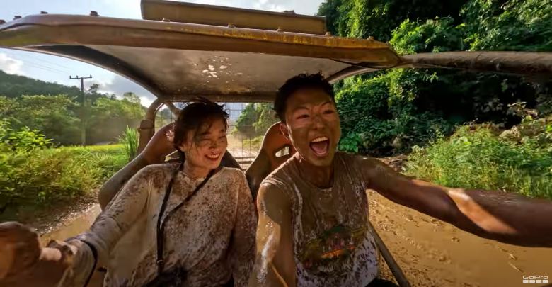 two young women covered in mud crossing a dirt road