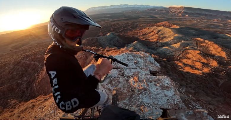 young man riding his bicycle on the mountains and desert recording with his gopro