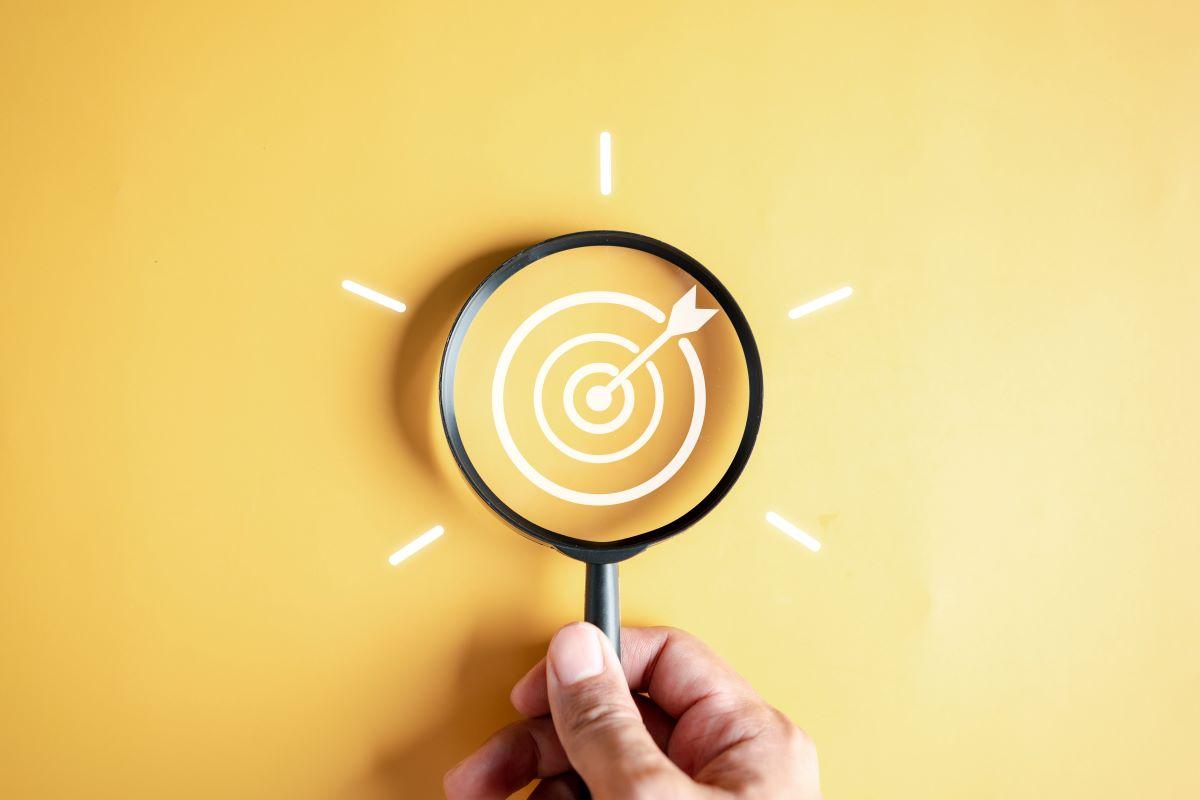 magnifying glass on a bullseye with a yellow background