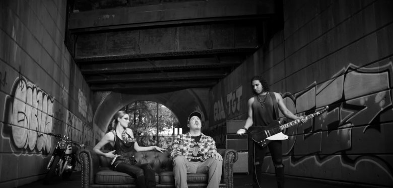 a man and a woman sitting on a sofa and a guitarrist under a bridge