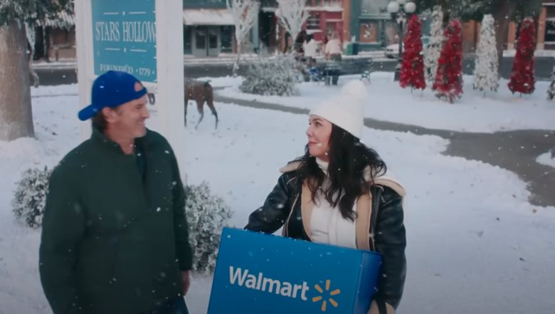 woman carrying a walmart box and talking with a man