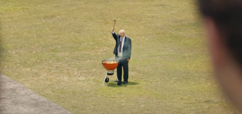 senior man happily grilling in a suit