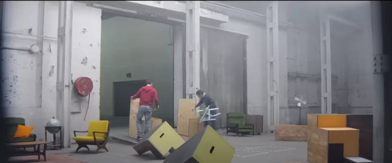 two men moving furniture around in big building