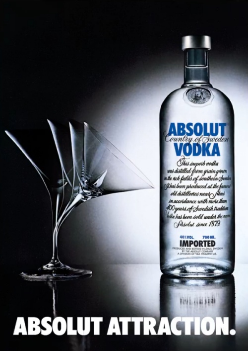 a martini glass bending towards absolut vodka bottle due to attraction