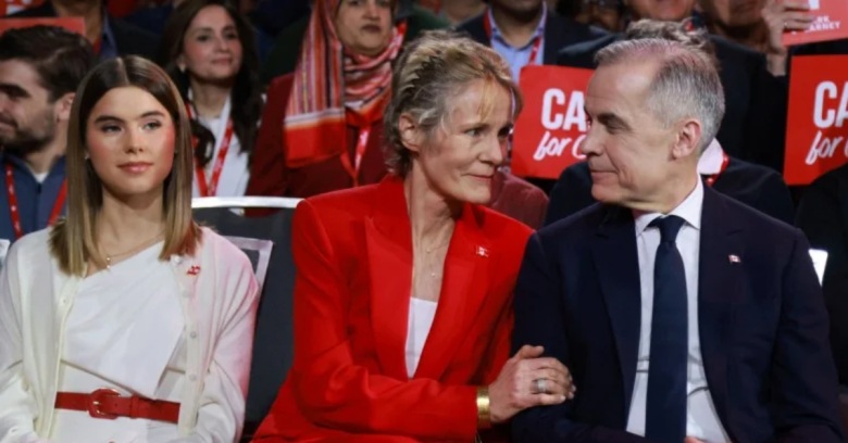 mark carney sitting next to a woman in a red blazer