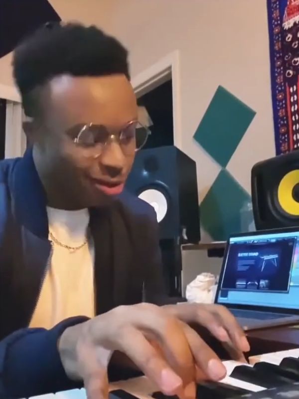 young black man playing the piano at home