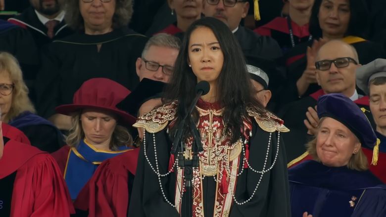 Yurong Jiang looking disappointed while giving a speech at Harvard