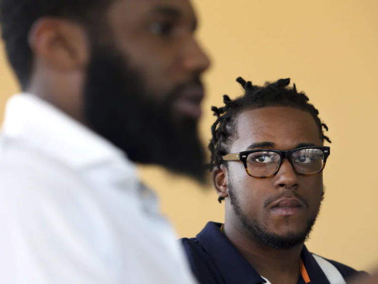 Man with glasses listening intently in a conversation with another man