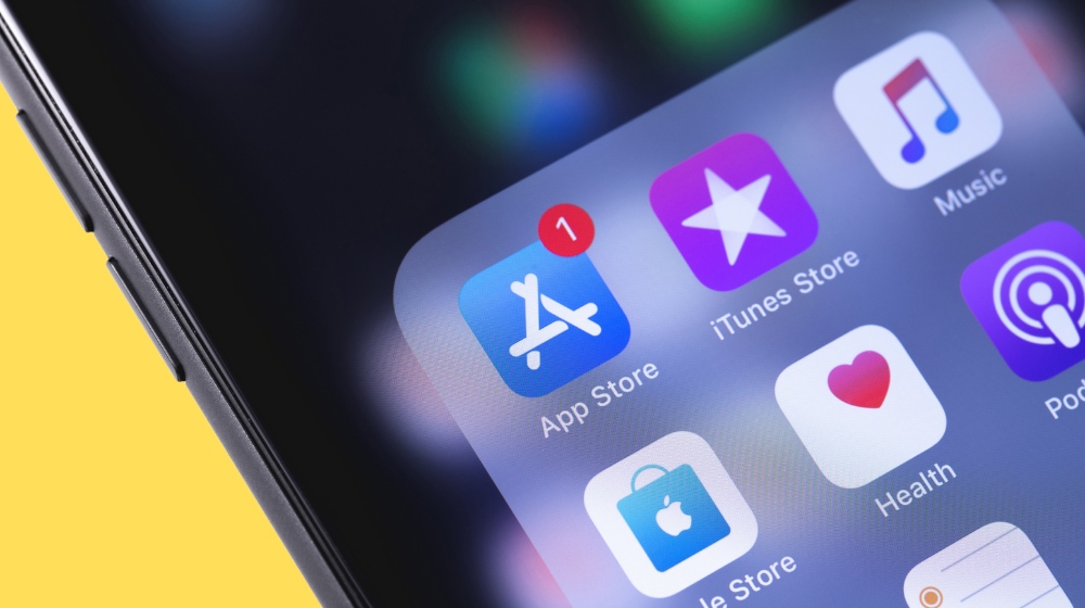 Close-up of iPhone screen with App Store, iTunes Store, Music, Health, and Podcast app icons