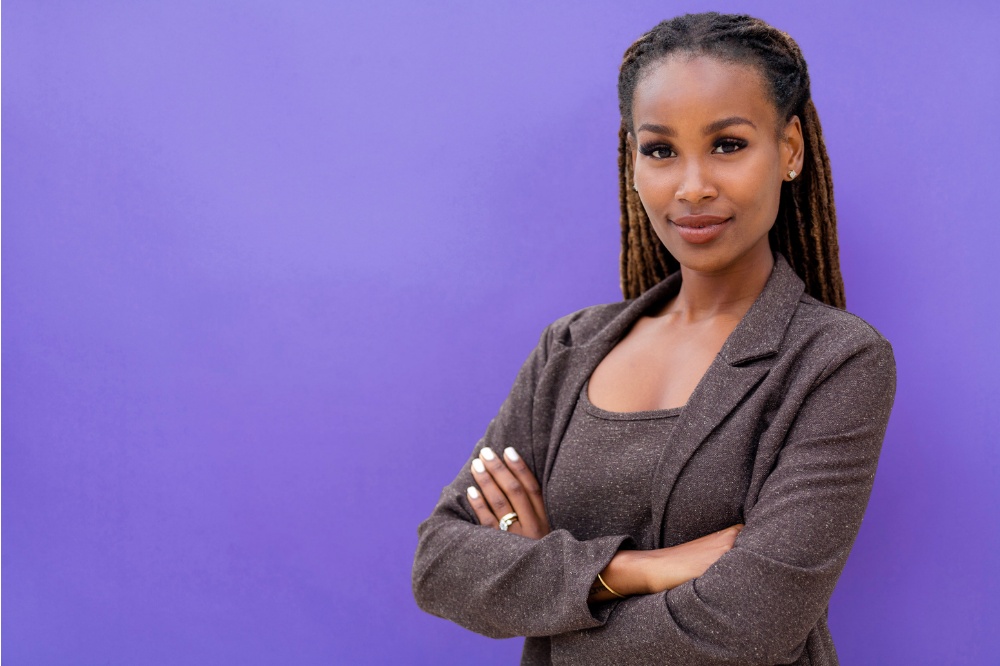 Confident woman in suit against purple background
