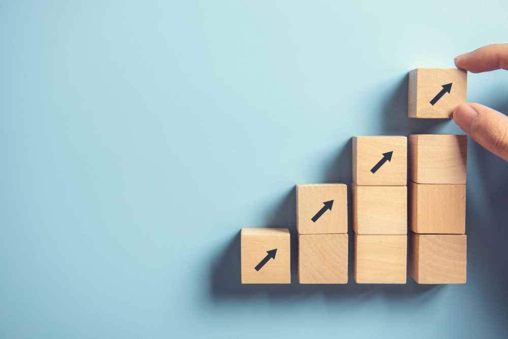 Hand stacking blocks with upward arrows