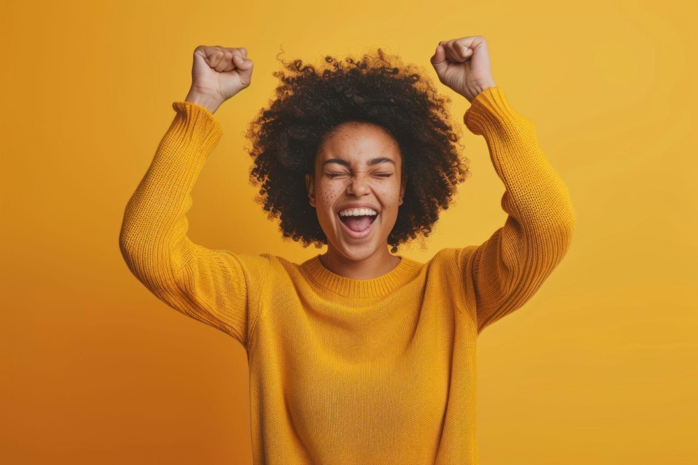 Joyful woman celebrating in yellow sweater