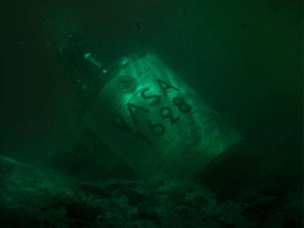 Submerged VASA 1628 bottle on ocean floor with green underwater background