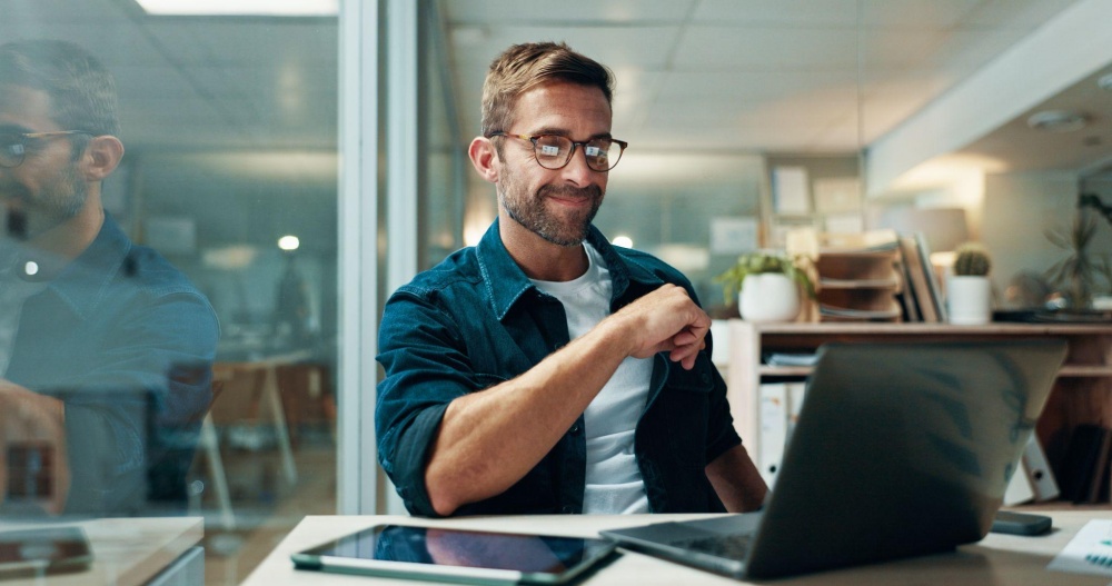 Man working at desk with laptop and tablet