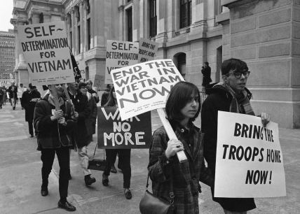 Protesters marching with signs like 'End the War in Vietnam Now' and 'Bring the Troops Home Now'