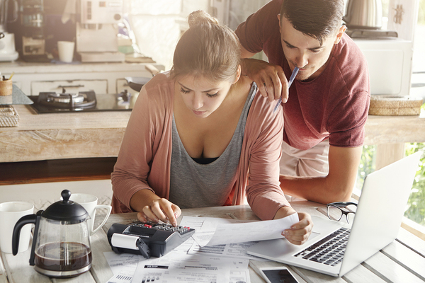 Couple using a calculator and laptop together.