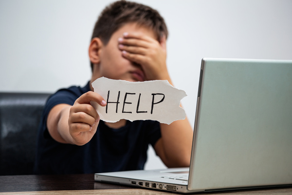 Young teen holding a help sign.
