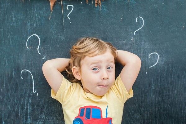 Child with question marks around his head.