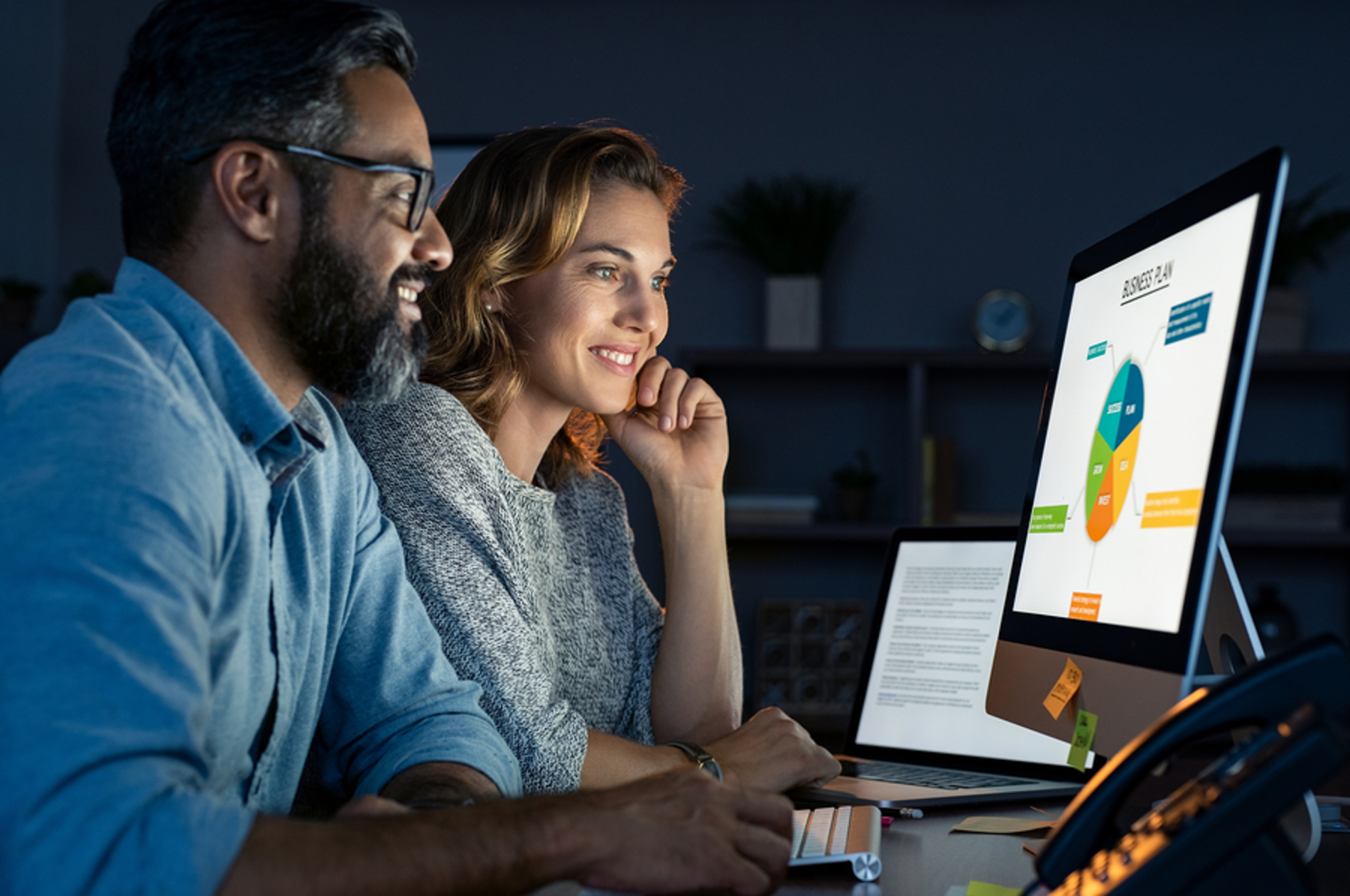 Two smiling people looking at a computer screen. Two smiling people looking at a computer screen.