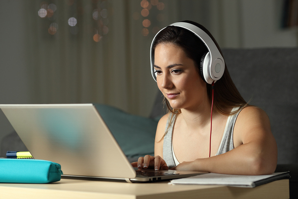 Woman working at a desk with headphones on.