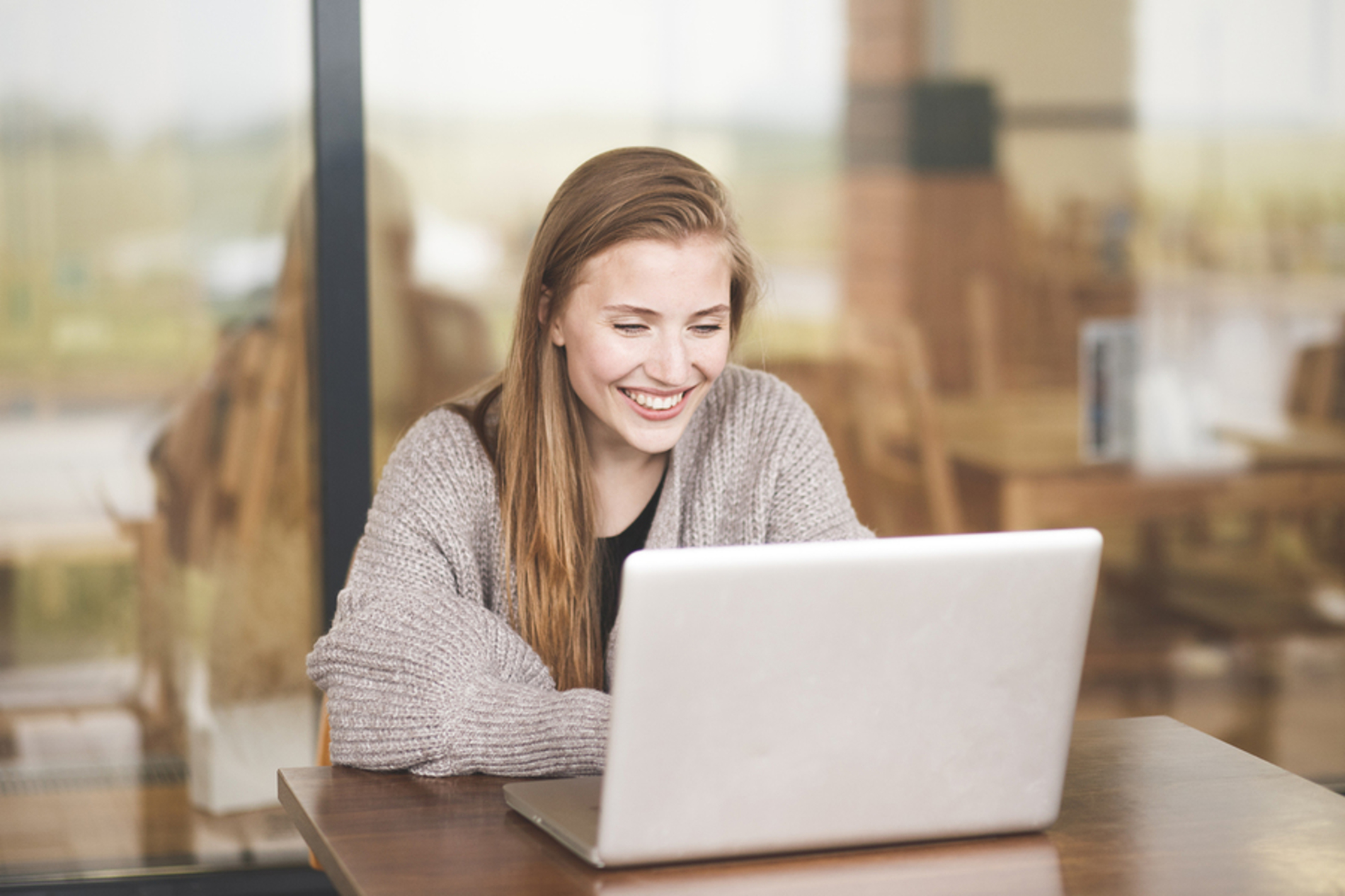 Woman at her desk looking at her laptop screen. Woman at her desk looking at her laptop screen.