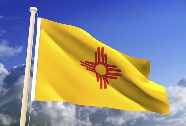 New Mexico flag flying with a blue sky in the background