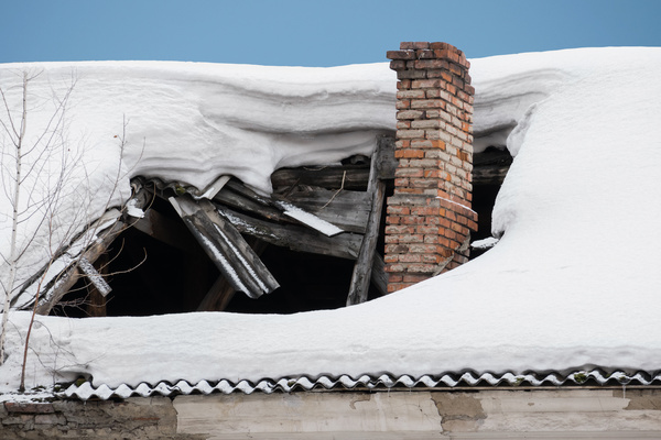 Snow on a roof with a large hole.