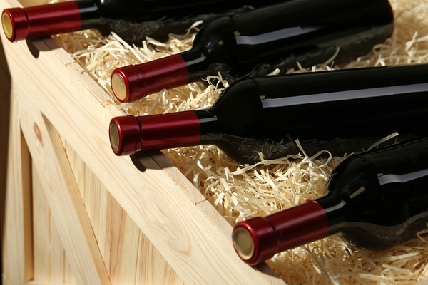 Wine bottles on top of a crate filled with hay.