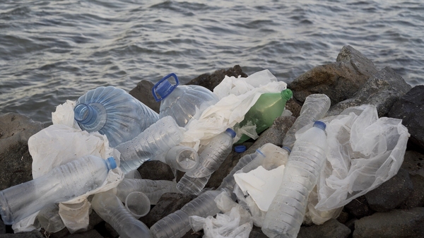 Plastic water bottles and bags on a beach.