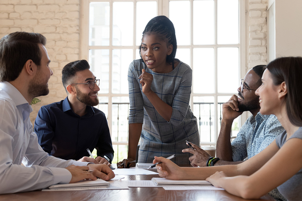 Woman speaking to a group of colleagues.