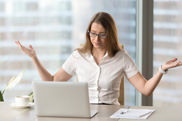 Woman questioning a problem on her laptop computer.