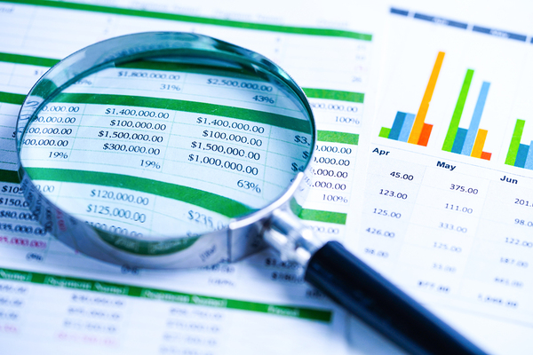Spreadsheet with magnifying glass.