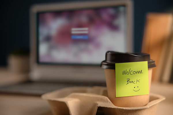 Coffee cup with a sticky note labeled "welcome back".