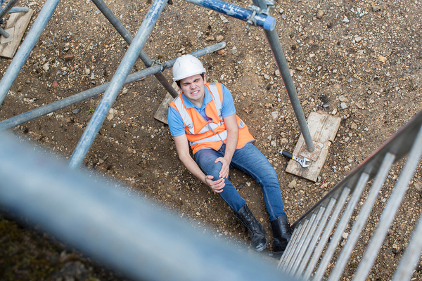 Construction worker holding knee in pain