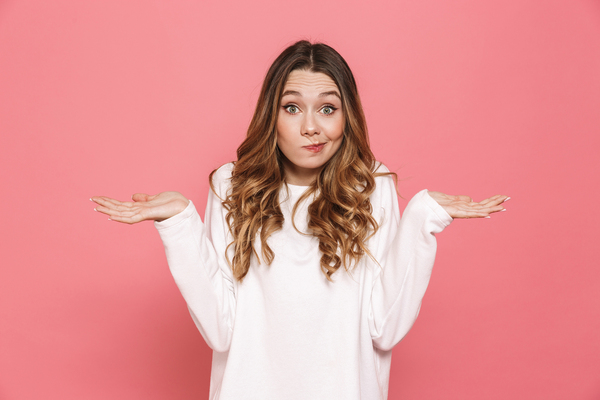 Woman holding her hands palms up appearing unsure.