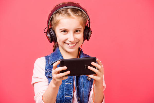 Smiling girl with headphones and mobile phone