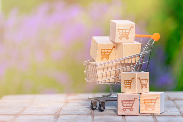 Miniature shopping cart filled with small packages.