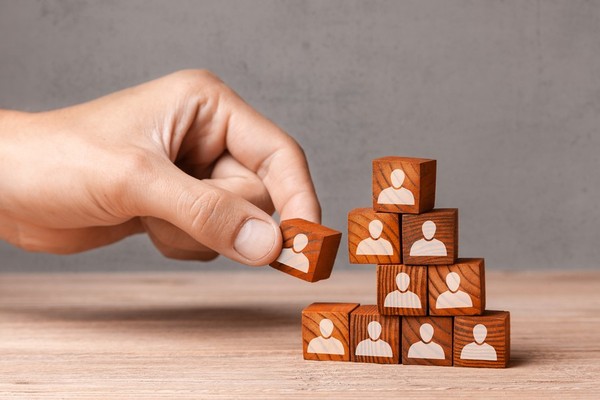 Person placing blocks in a pyramid shape.