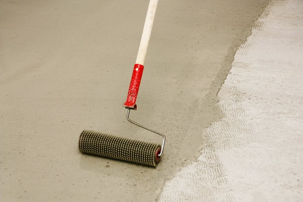 Floor being painted beige with paint roller