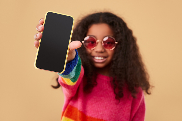 Young teen holding up her phone.